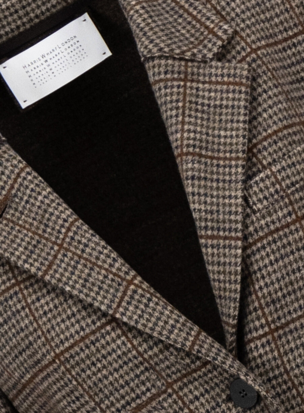 close up flat lay of printed blazer neckline, showing brand's logo tag