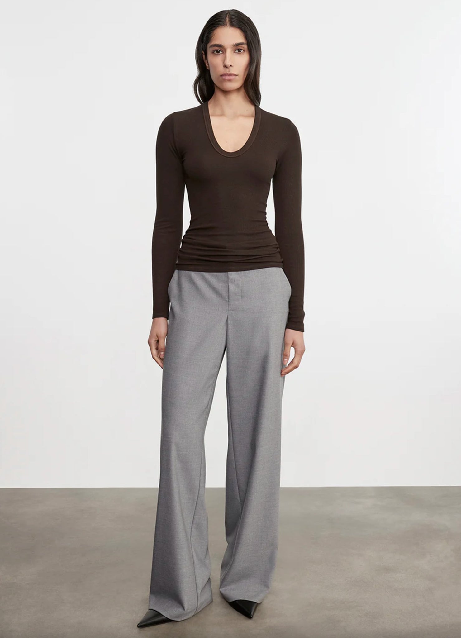 ENZA COSTA COLLECTION IMAGE SHOWING MODE WEARING BROWN SILK KNIT LONG SLEEVE TOP AND GREY TROUSERS