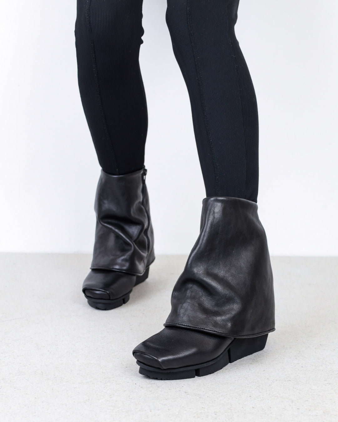 TRIPPEN FW25 COLLECTION IMAGE SHOWING MODEL FROM THE KNEE DOWN WEARING THE TRIPPEN PERMA BLACK ANKLE BOOT