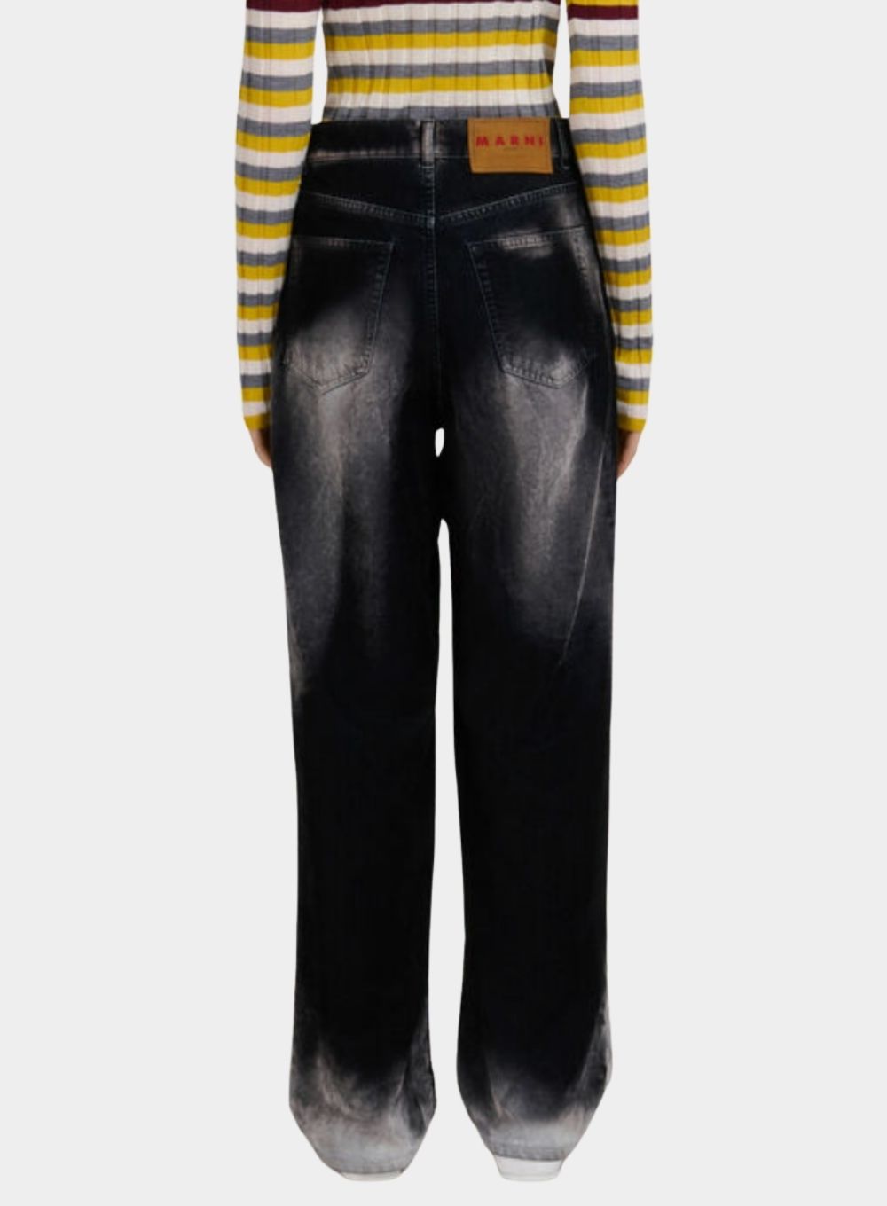 Black leather pants worn with a striped sweater on a white background