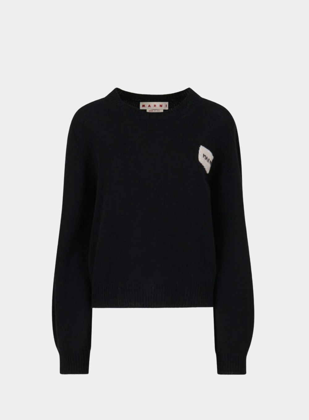 Black sweater with a small white patch on a light gray background