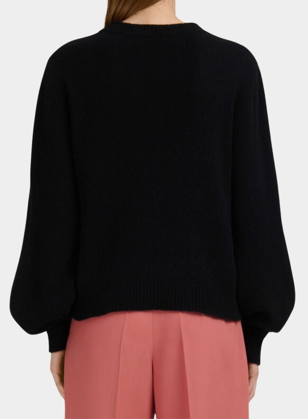 Black sweater worn by a person on a white background