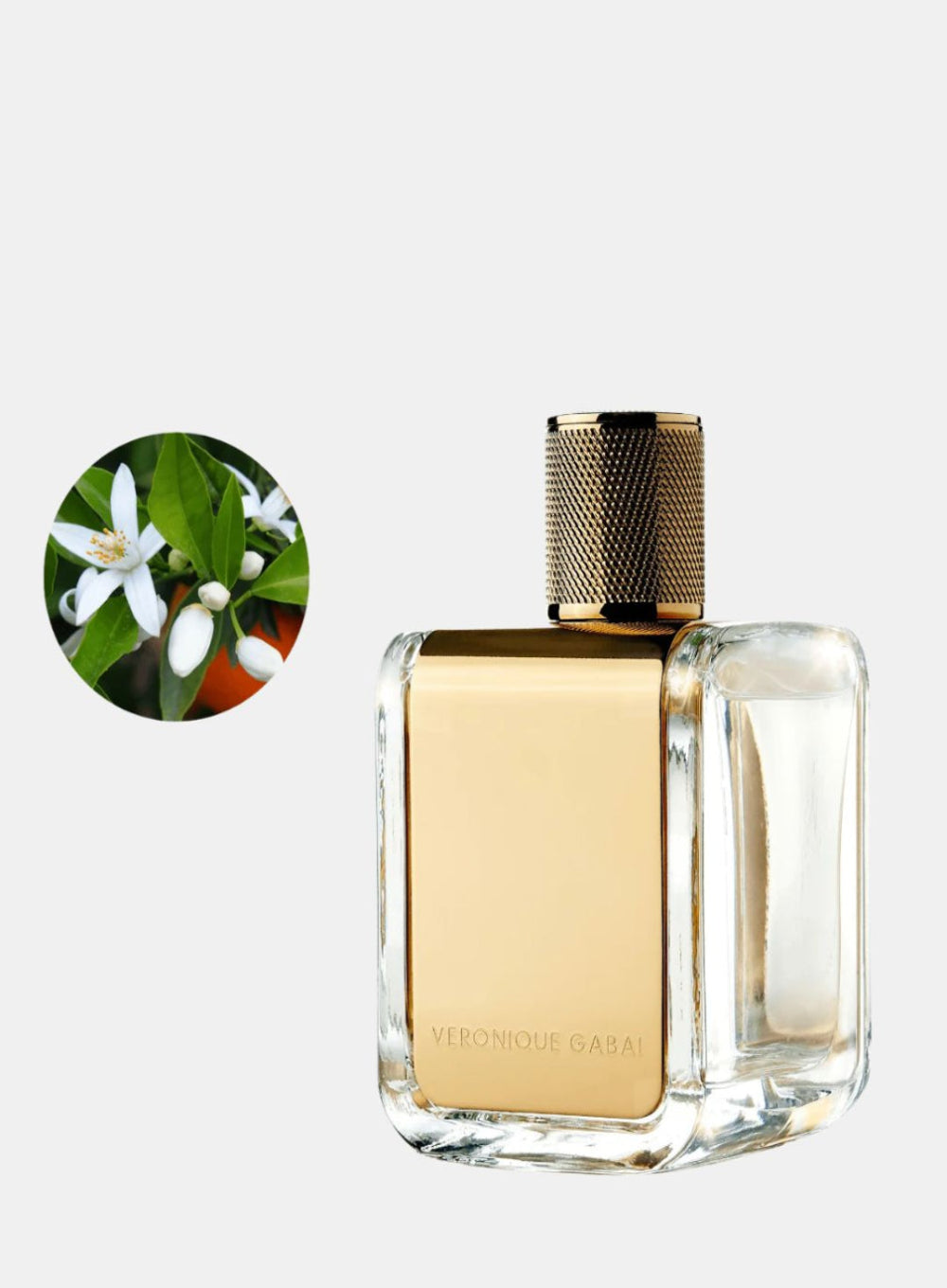 Perfume bottle with gold cap and clear body on a white background, featuring a close-up of flowers in the corner.