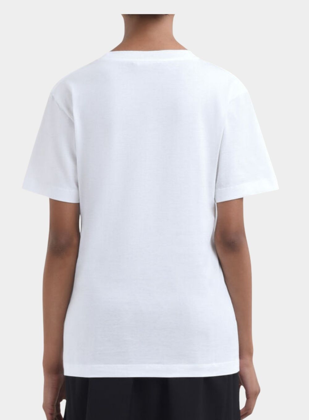 White t-shirt worn by a person on a plain background