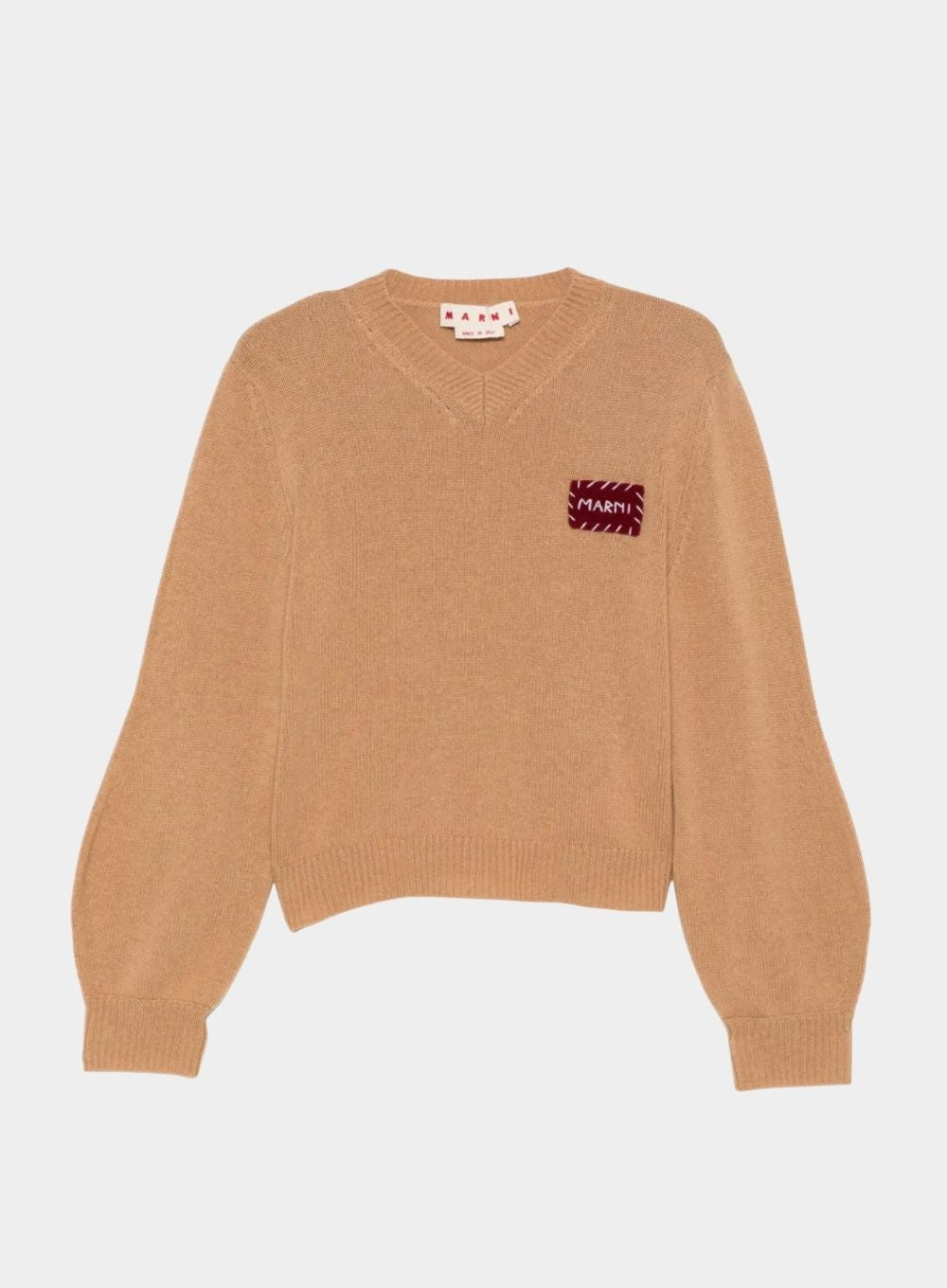Brown sweater with a small red and white pattern on a light gray background