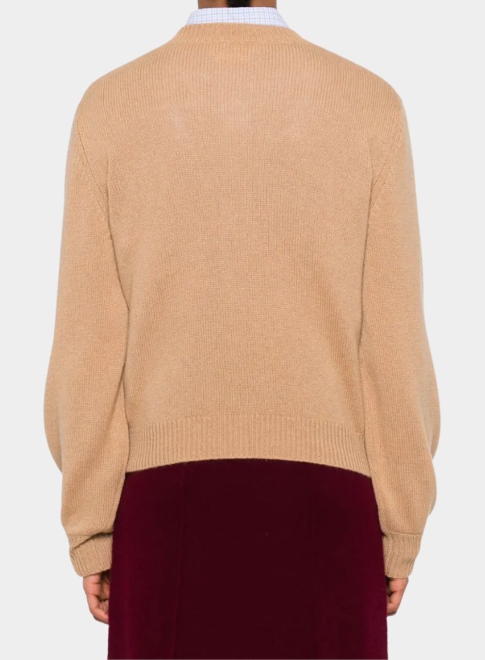 Beige sweater worn by a person on a white background