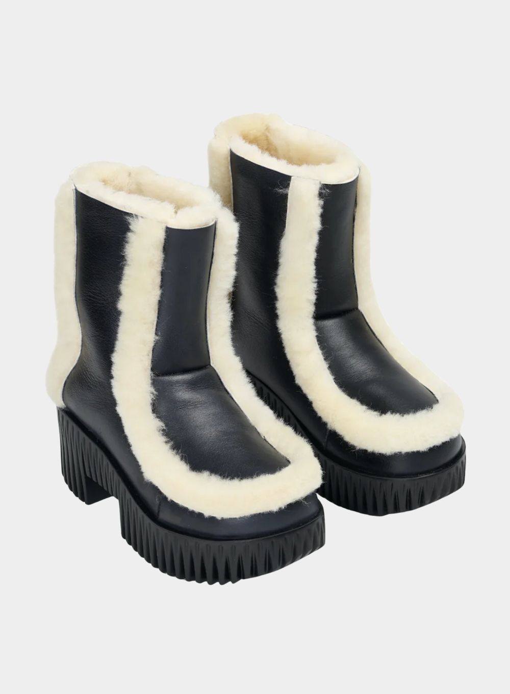 Black boots with white fur trim on a white background