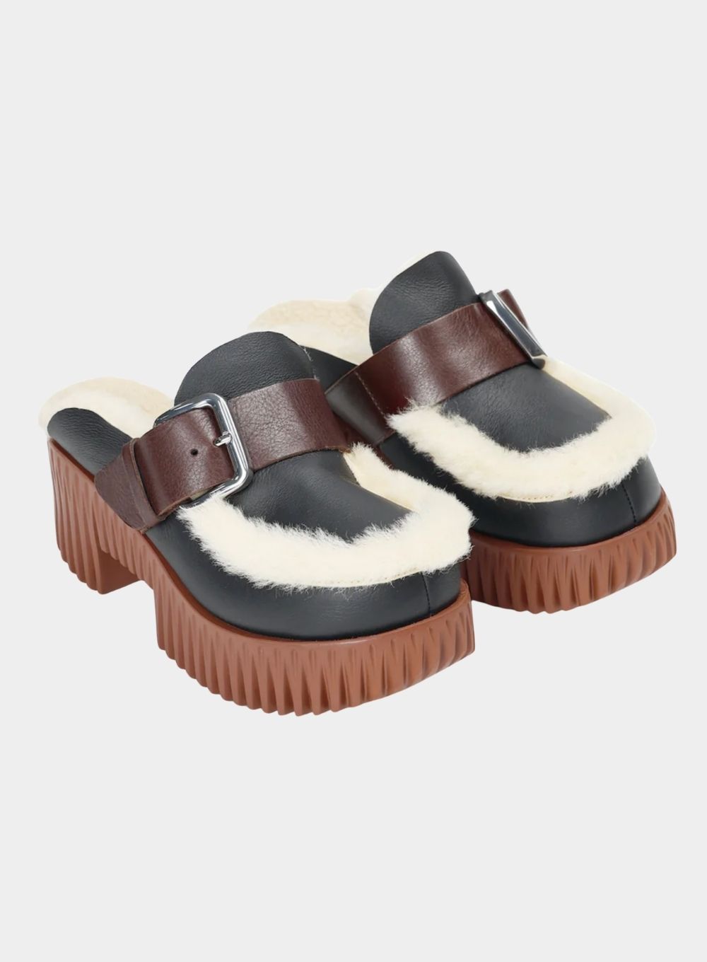 Black clogs with brown soles and straps on a light gray background