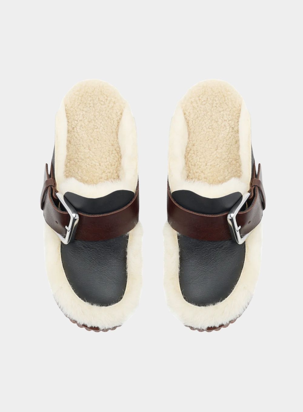 Pair of black clogs with brown straps and white sheepskin soles on a light gray background