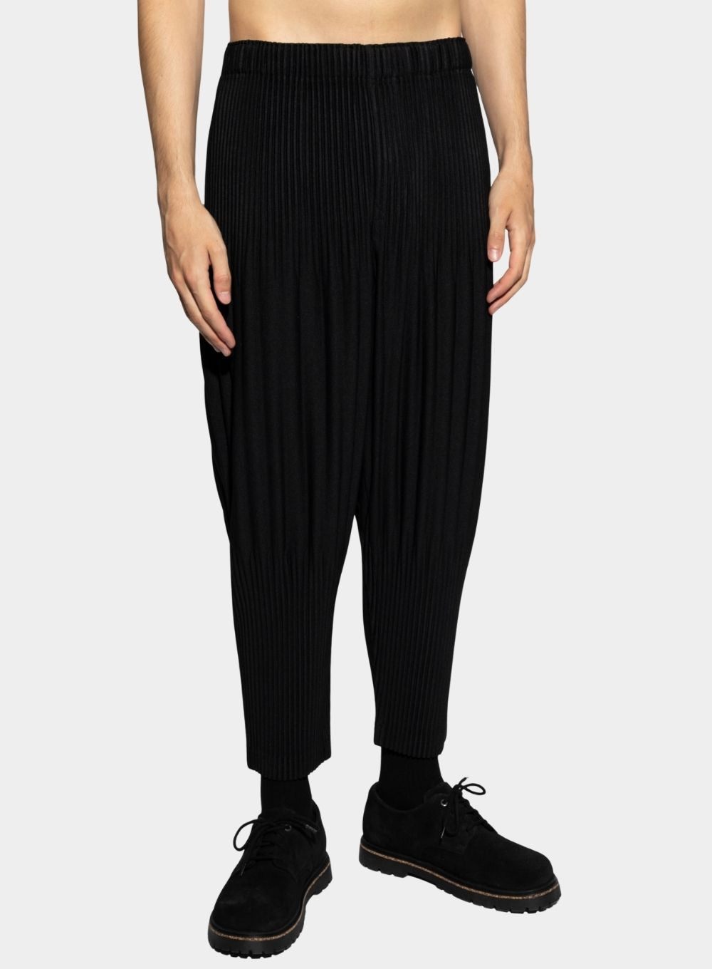 Person wearing black ribbed knit pants on a white background