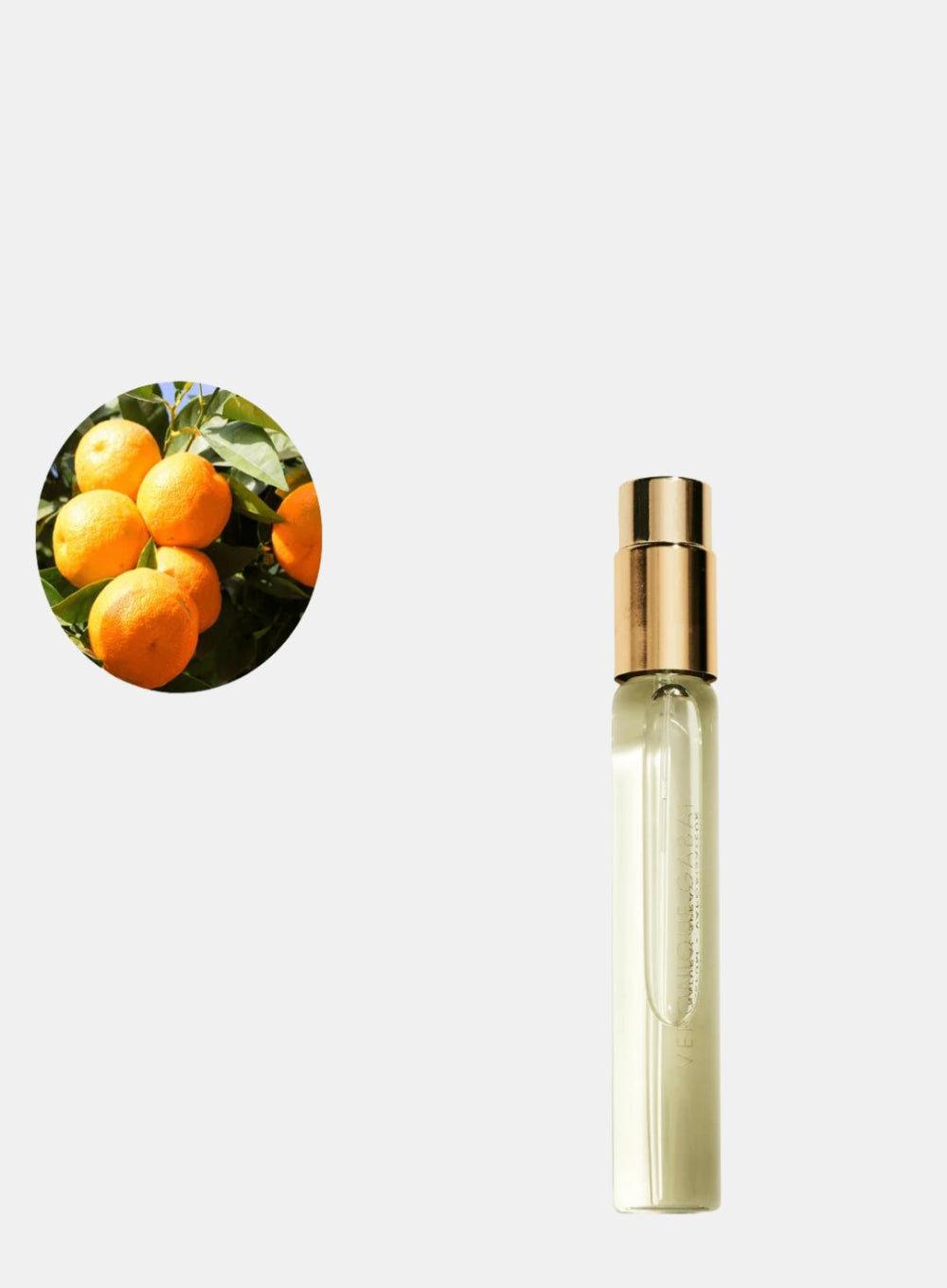 Perfume bottle with a gold cap on a white background, inset of oranges on the left.