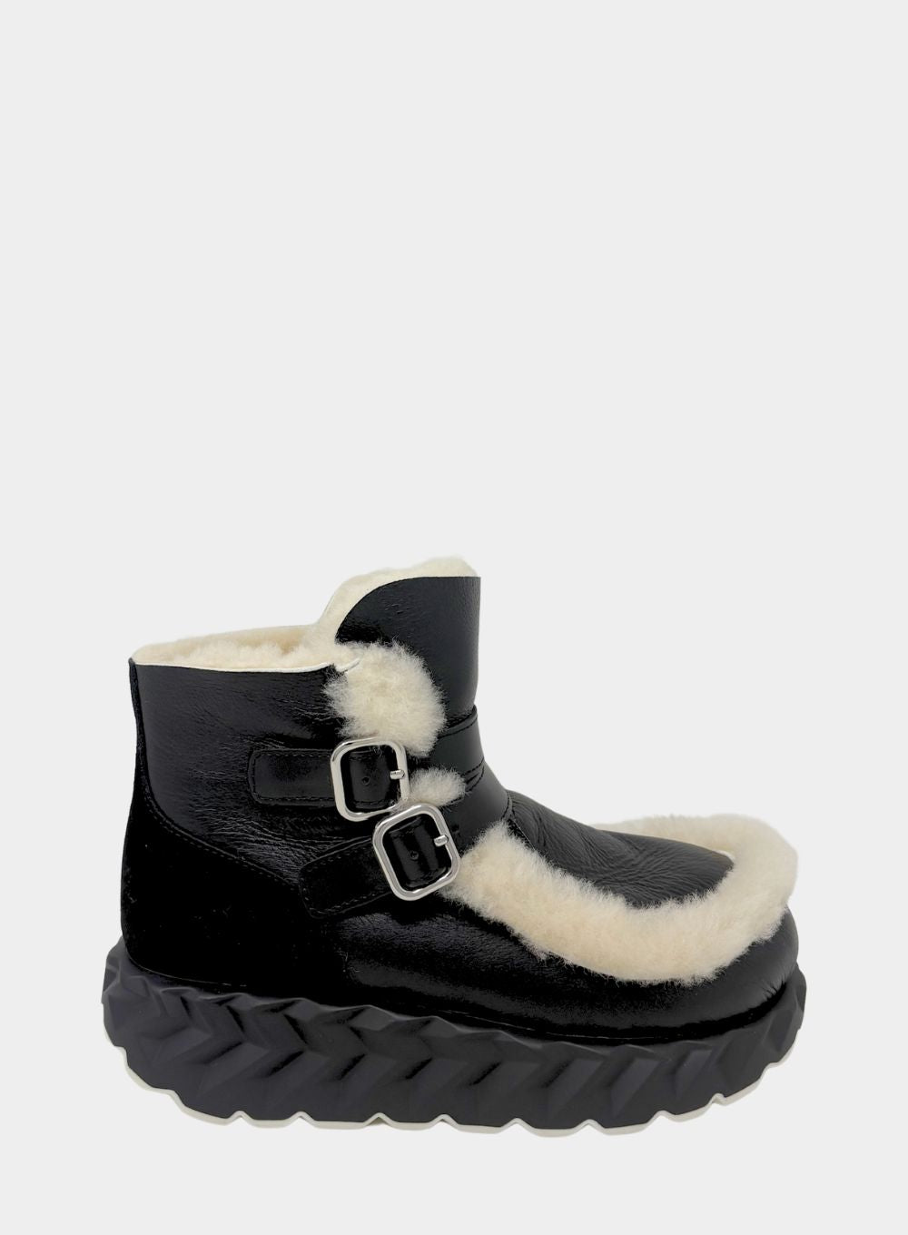 Black boot with white fur lining on a light gray background
