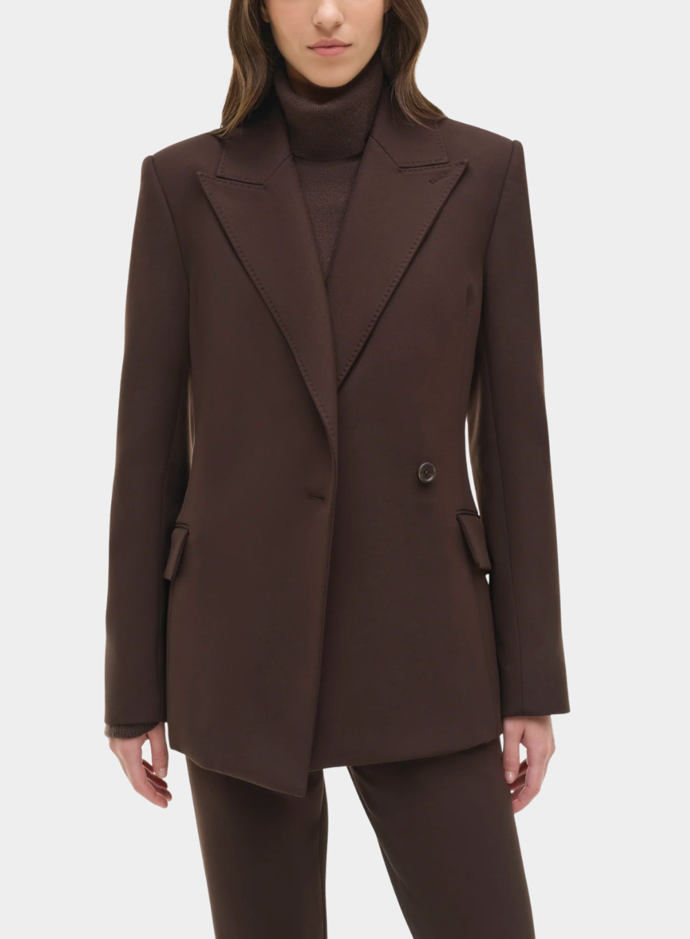 Brown suit jacket worn by a person on a white background