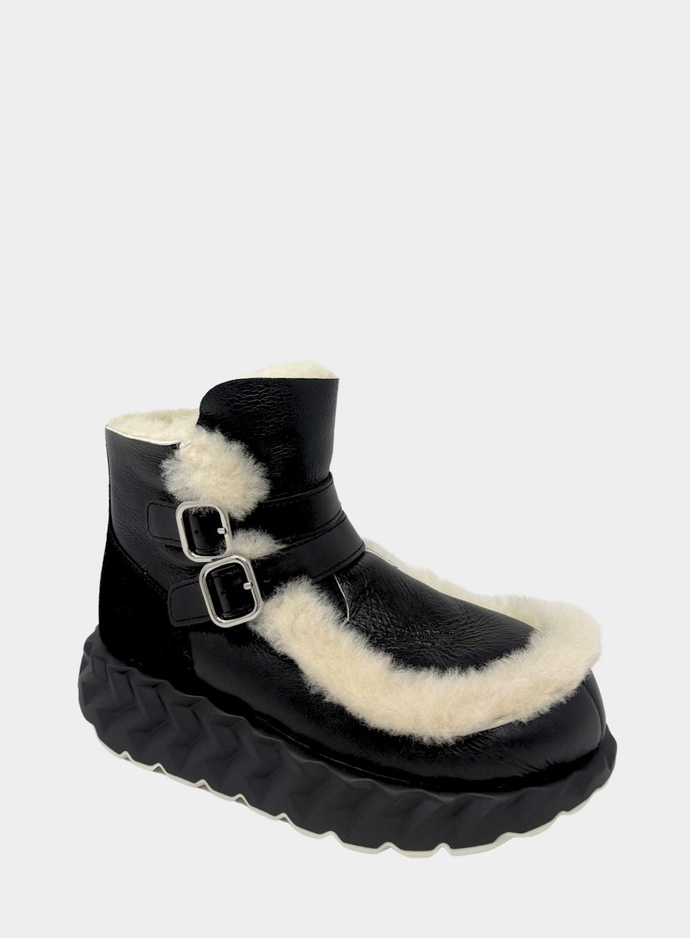 Black boot with white fur lining on a light gray background