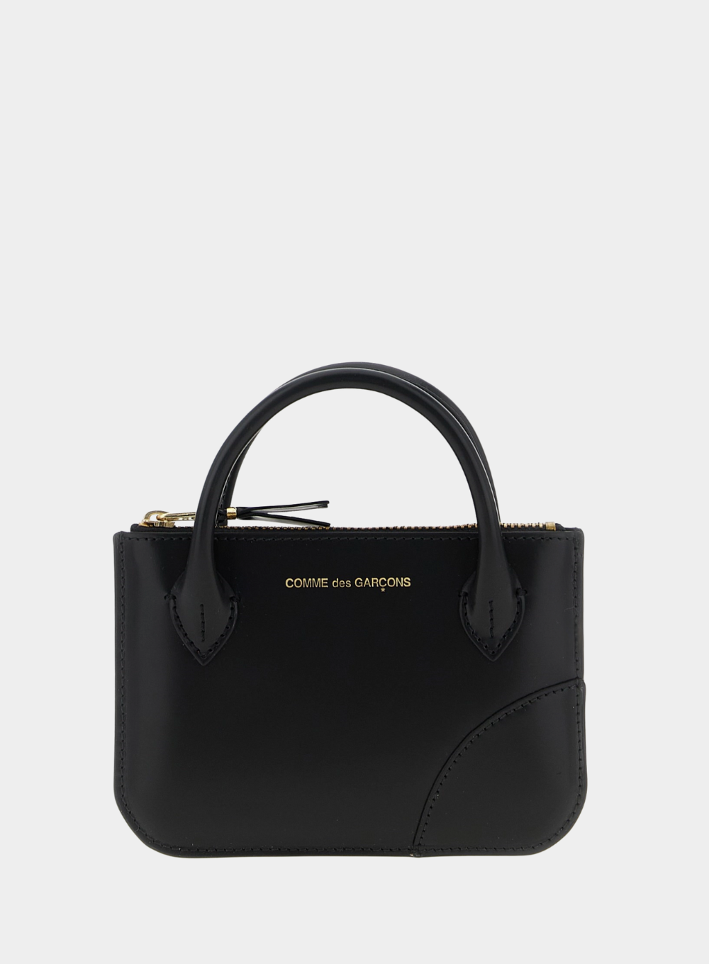Black handbag with 'Comme des Garçons' branding on a white background