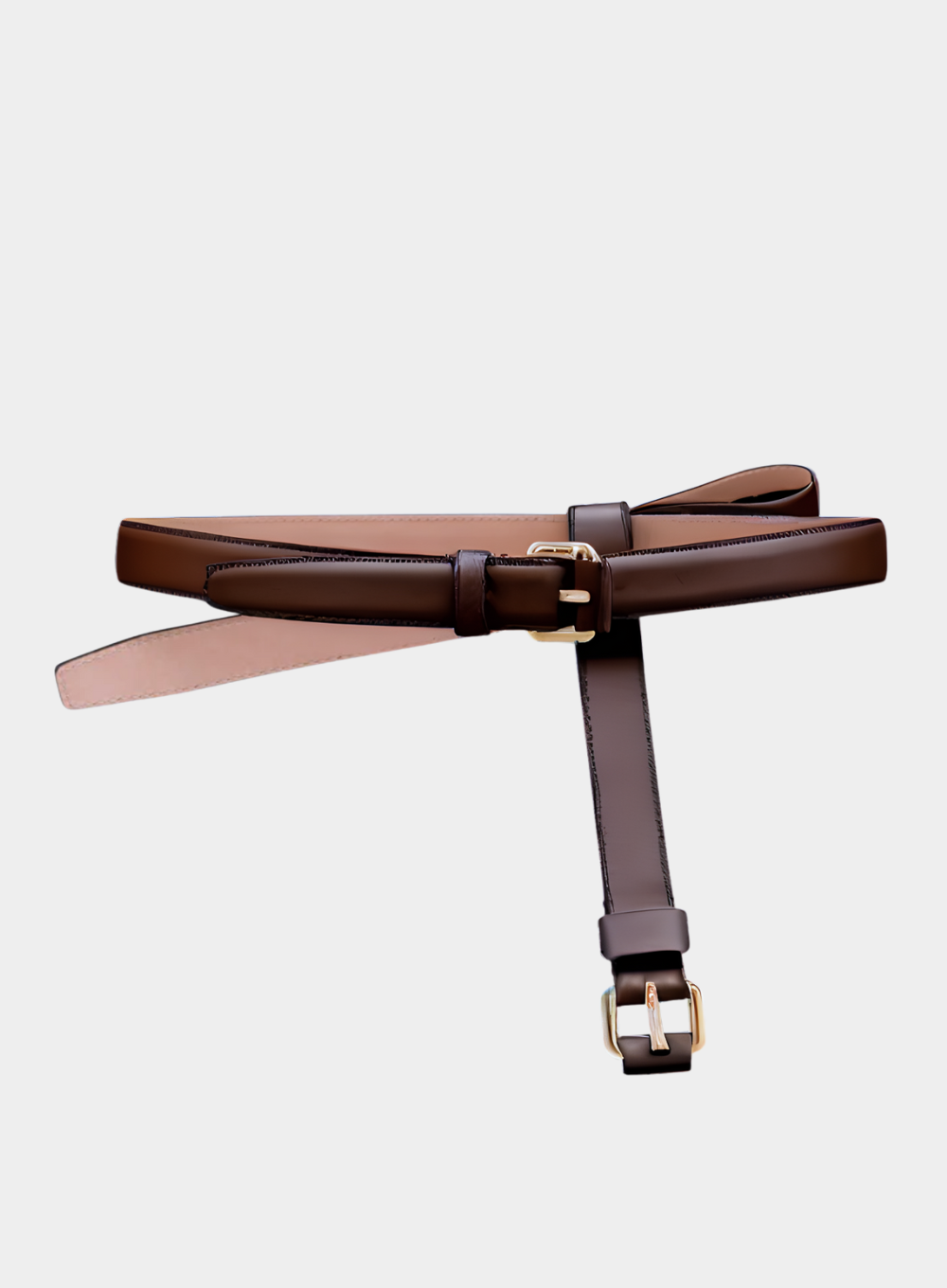 Brown leather belt with gold buckle on a light gray background